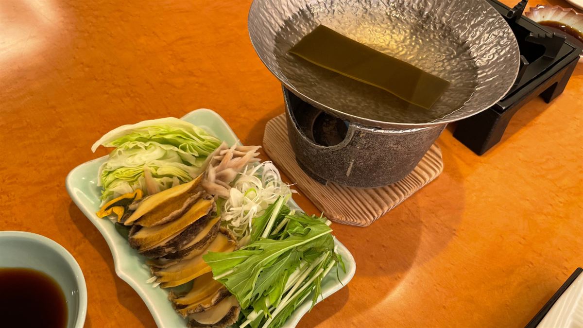 薄切りの鮑と野菜、昆布を敷いた小鍋