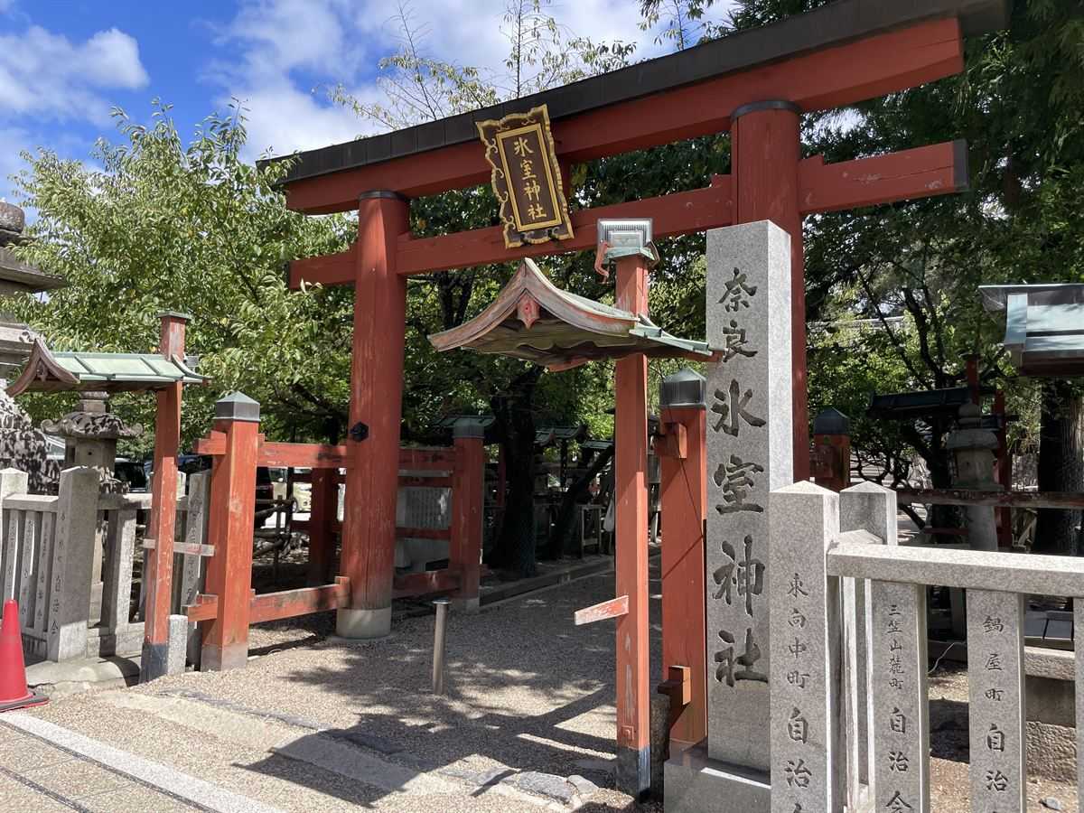 氷室神社の朱塗りの鳥居。扁額に「氷室神社」、手前に「奈良 氷室神社」の石柱