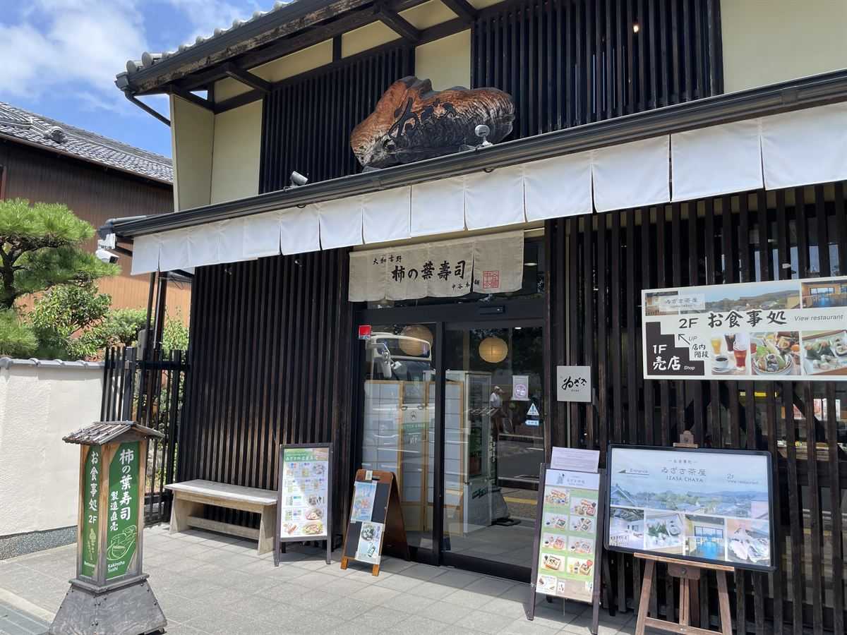 ゐざさ 東大寺門前夢風ひろば店の外観。黒い板張りの建物に「柿の葉寿司」の看板が出ている