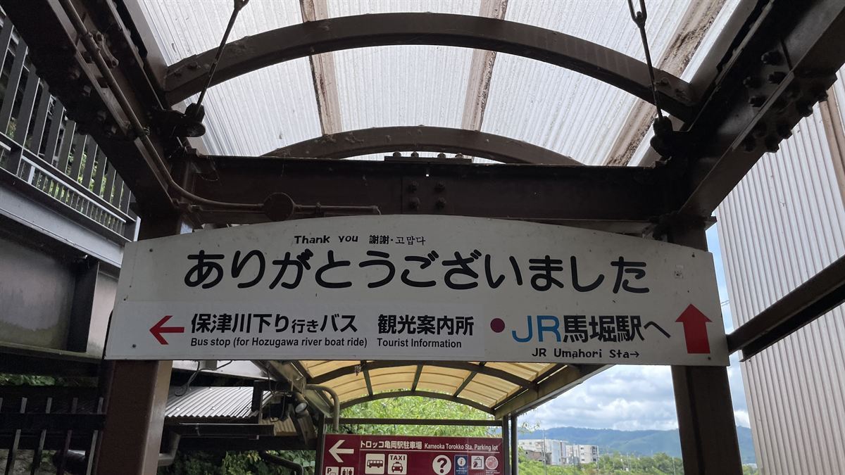 トロッコ亀岡駅の出口にある案内看板。「保津川下り行きバス」「観光案内所」「JR馬堀駅へ」と書かれている