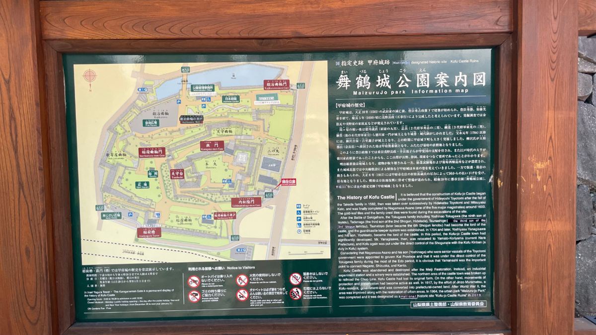甲府城跡の舞鶴城公園案内図。園内マップと甲府城の歴史の解説が並ぶ木枠の案内板