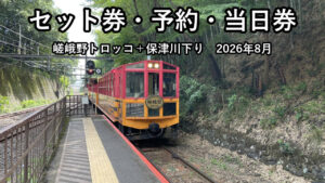 嵯峨野トロッコ列車がトロッコ嵐山駅のホームに停車している。赤と黄の車体に「嵯峨野 ROMANTIC TRAIN」のエンブレム
