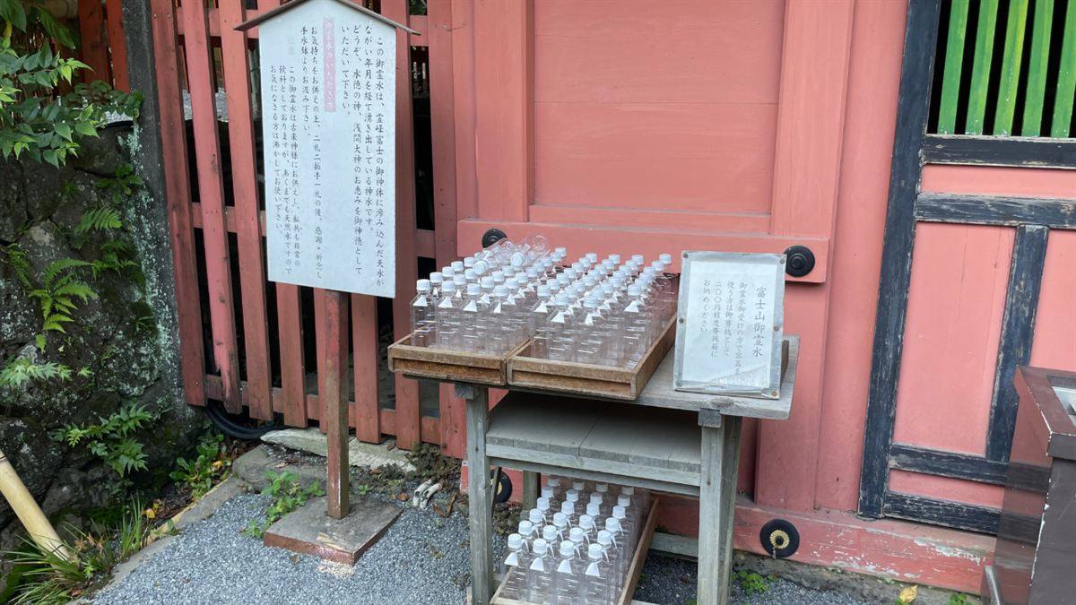 水屋神社の御霊水の水汲み場。「御霊水のいただき方」の案内板と、用意された空のペットボトル