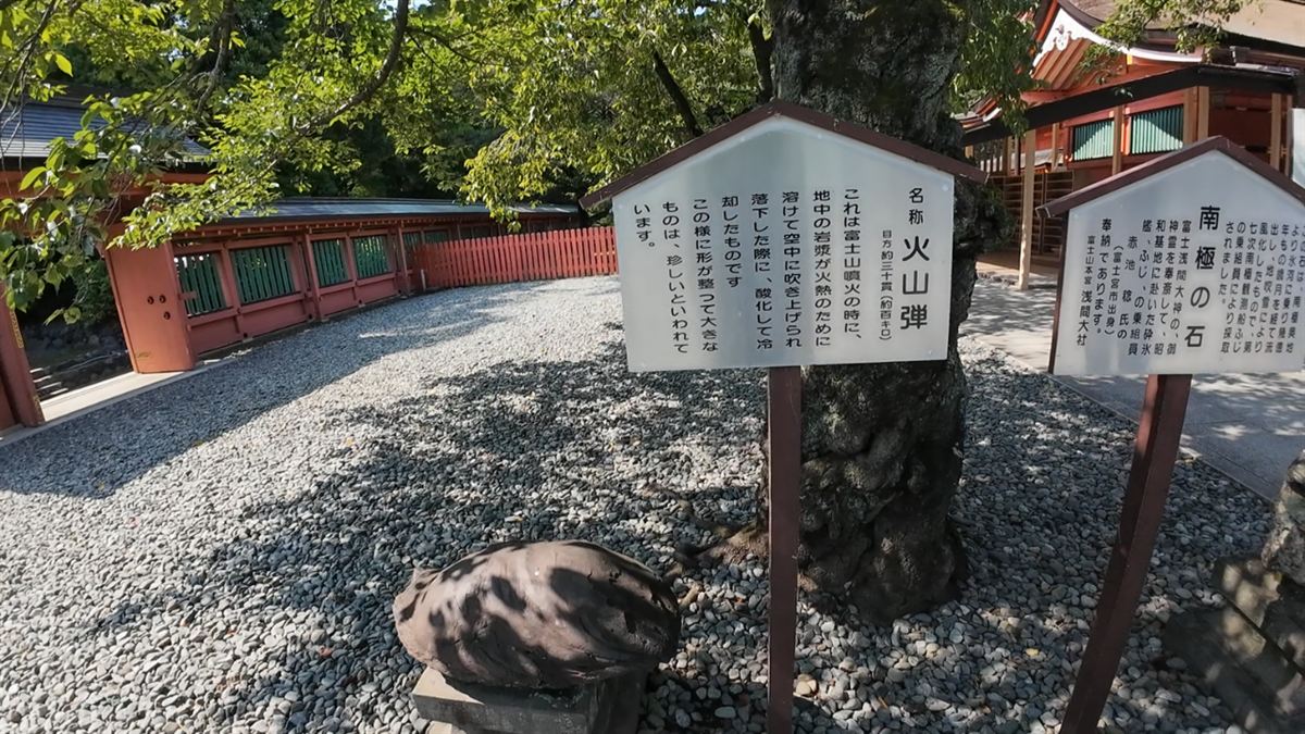 「火山弾」の説明板と、その手前に置かれた黒い火山弾