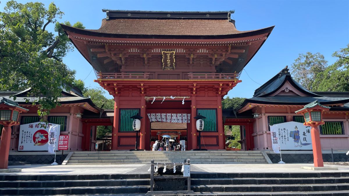 富士山本宮浅間大社の朱塗りの楼門と、手前に注連縄で囲まれた鉾立石