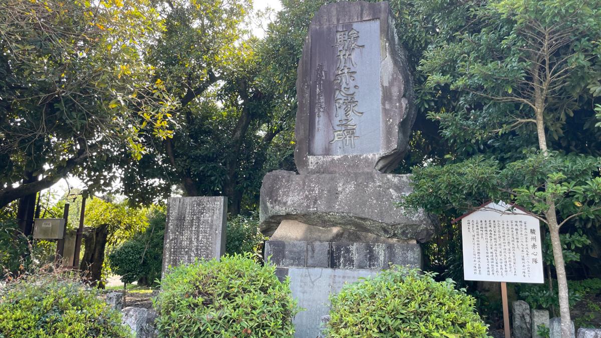 「駿州赤心隊之碑」と刻まれた大きな石碑と、そばに立つ説明板