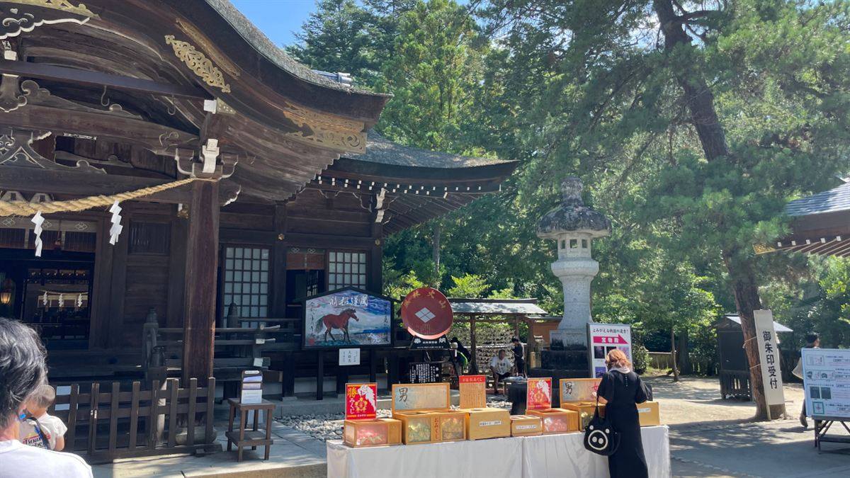 拝殿前に並ぶおみくじの箱と「御朱印受付」の案内