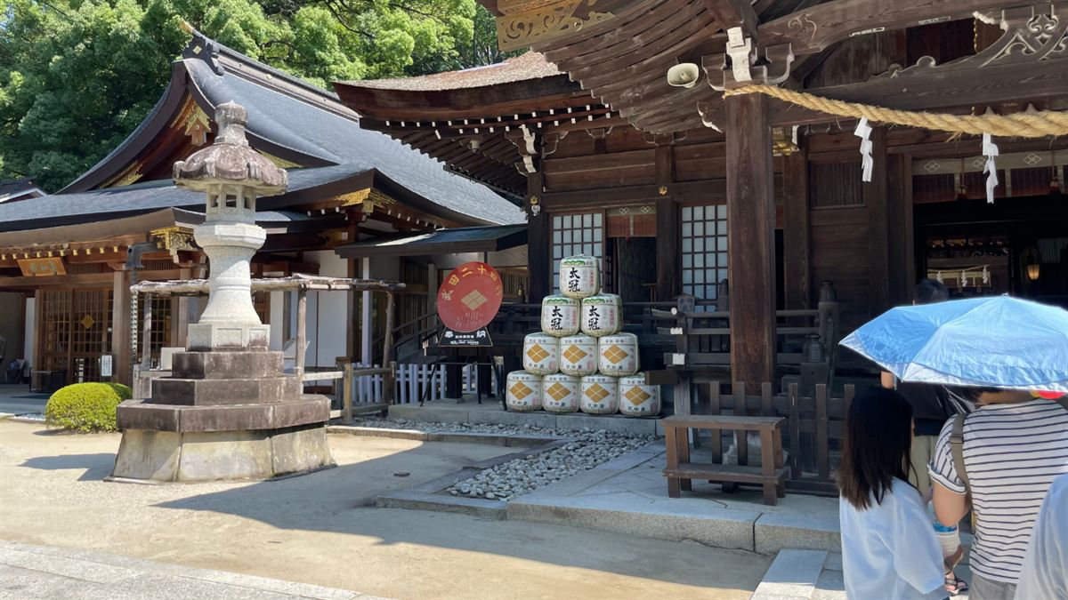 石灯籠の並ぶ武田神社の境内と拝殿、奉納樽