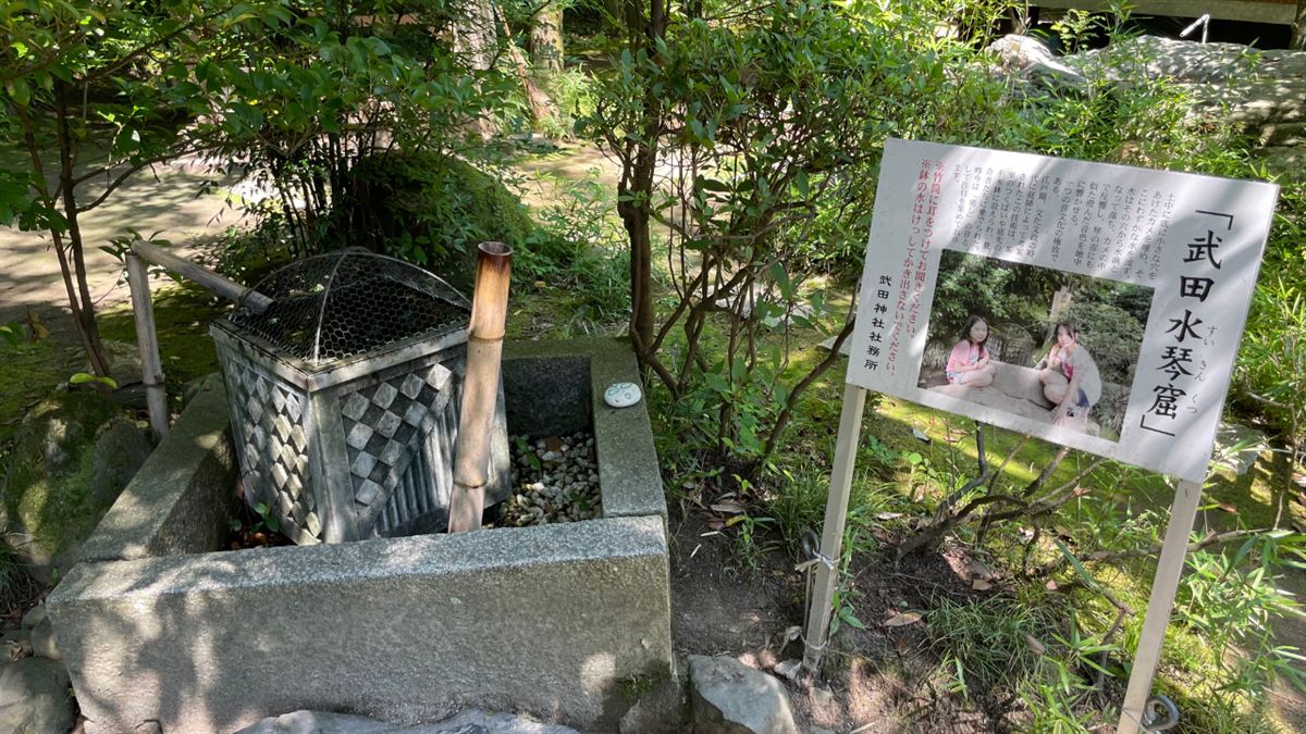 「武田水琴窟」の案内板と竹筒、水の見えない水鉢