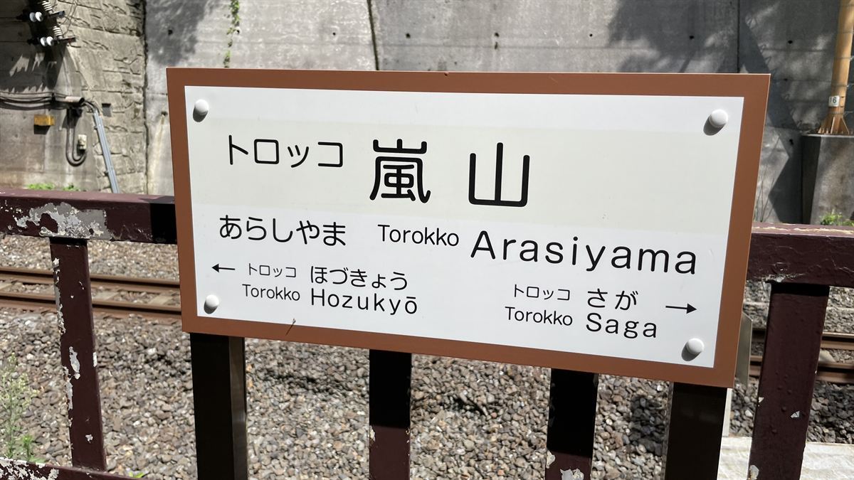 トロッコ嵐山駅のホームにある駅名標。「トロッコ嵐山」と書かれ、左右に保津峡・嵯峨の表示がある