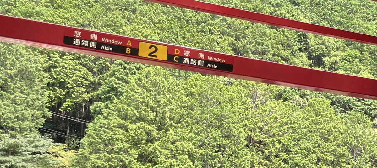 トロッコ列車の車内にある座席の表示。A席とD席が窓側、B席とC席が通路側と書かれている