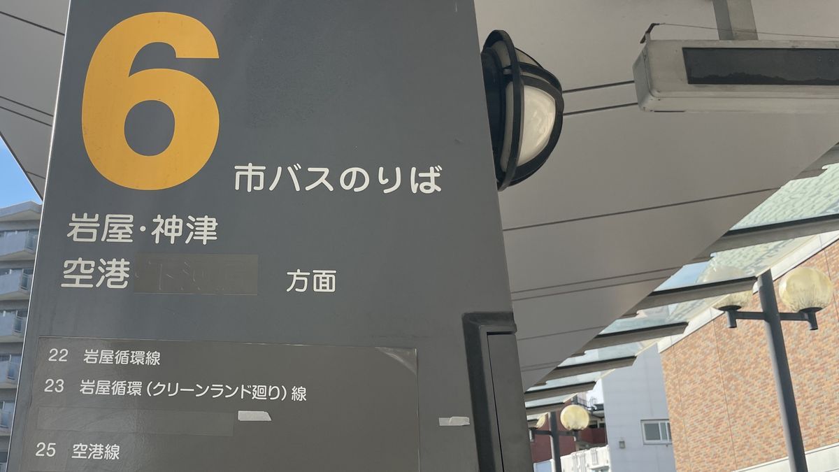 阪急伊丹駅前の市バスの6番のりばの柱。「市バスのりば 岩屋・神津 空港 方面」と書かれ、下に25 空港線などの系統が並んでいる
