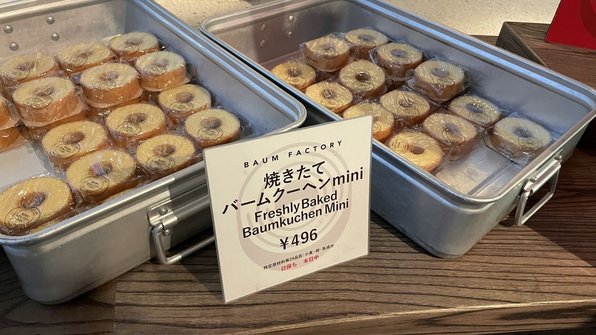 バームファクトリーの焼きたてバームクーヘンmini。四角い金属の箱に小さなバームクーヘンが並び、496円の札が立っている