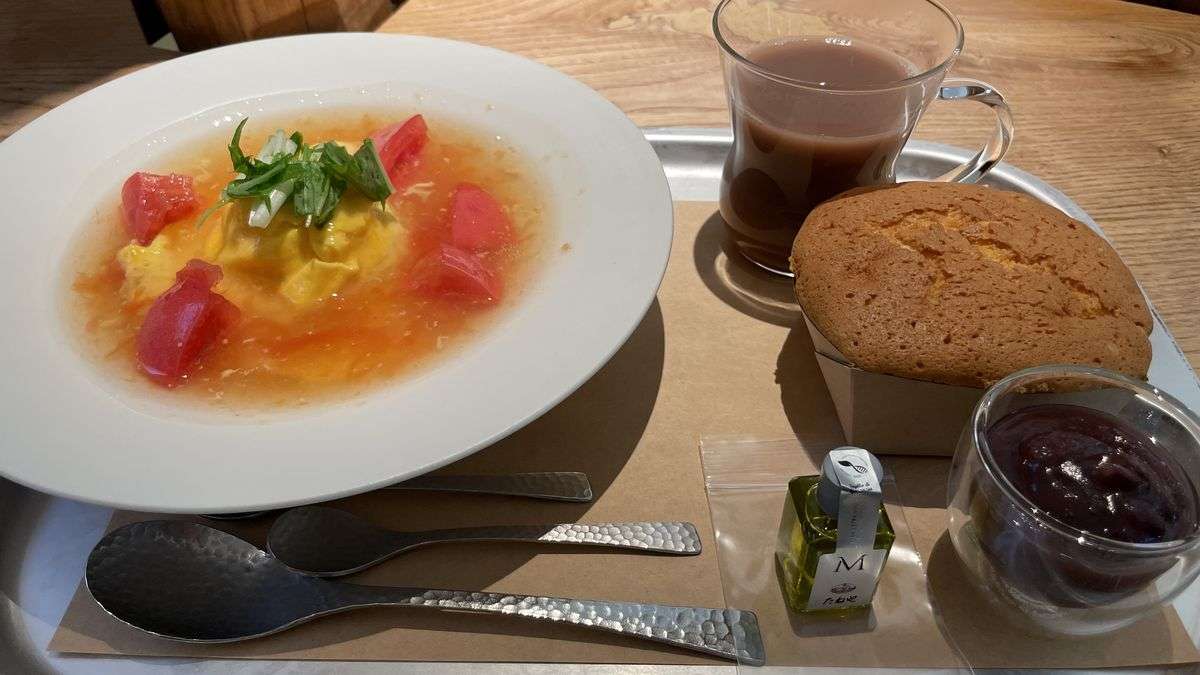 カステラショップのカフェのオムライスのセット。トマトがのったオムライスの皿、焼きたてのカステラ、あんこの器、小豆茶ラテ、オリーブオイルの小瓶がトレーに並んでいる