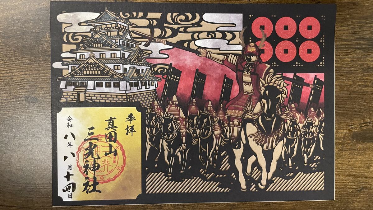 三光神社の切り絵の御朱印。大阪城と騎馬武者の切り絵に六文銭が入り、「真田山 三光神社」と書かれている