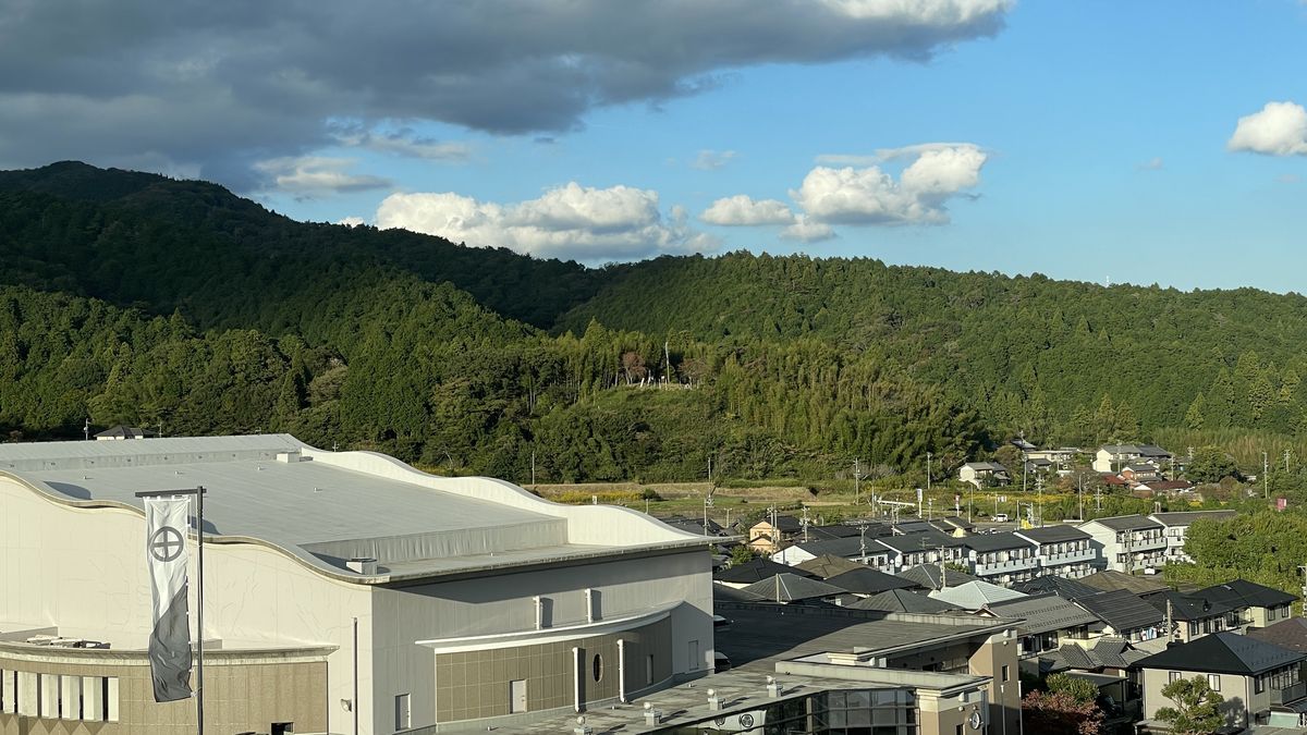 記念館の5階の展望室から見た関ケ原。手前に別館の白い屋根と旗、その先に家並みと森の山が広がっている