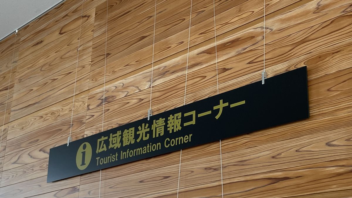 記念館の1階の「広域観光情報コーナー Tourist Information Corner」の看板。木の壁に文字が並んでいる
