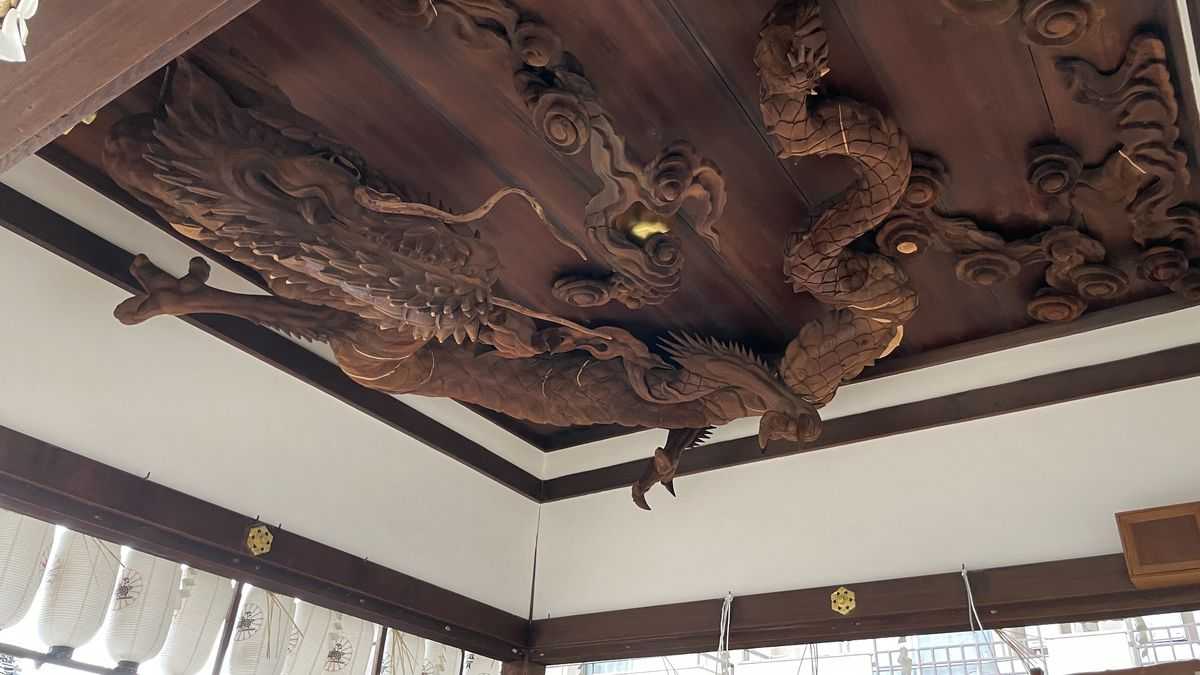 瀧尾神社の拝殿の天井に彫られた木彫りの龍。うろこのある長い胴体が、天井いっぱいにうねっている