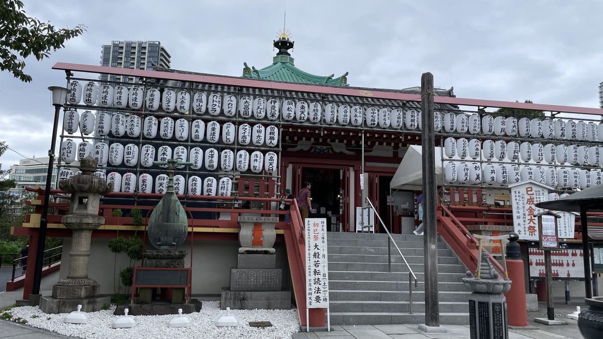 不忍池辯天堂の正面。赤いお堂の前に白い提灯が何段も並び、屋根の上に緑の八角の屋根が見える