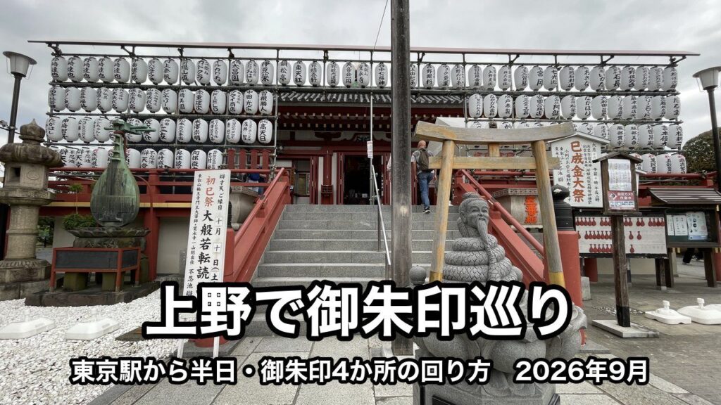 不忍池辯天堂の正面の石段。白い提灯が何段も並ぶお堂の前に、小さな鳥居の下の、とぐろを巻いた蛇の体に老人の顔の石像がある。下に「上野で御朱印巡り」「東京駅から半日・御朱印4か所の回り方　2026年9月」の文字が入っている