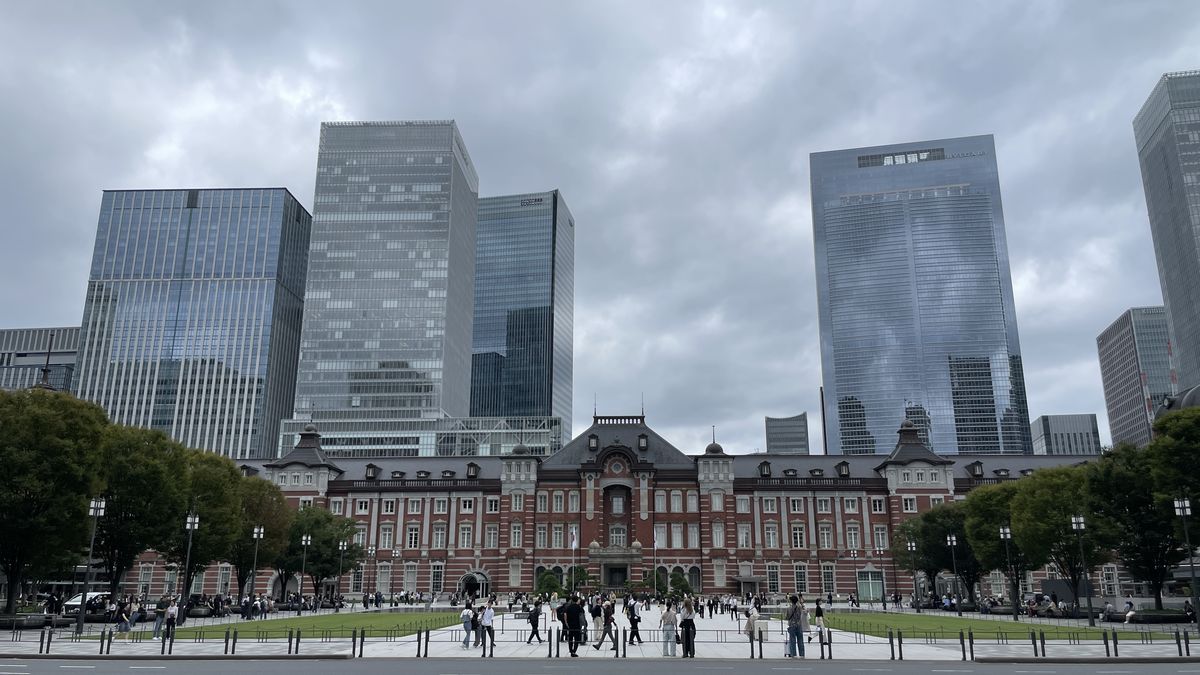 東京駅の丸の内駅舎。赤レンガの駅舎のうしろに、高いビルが並んでいる