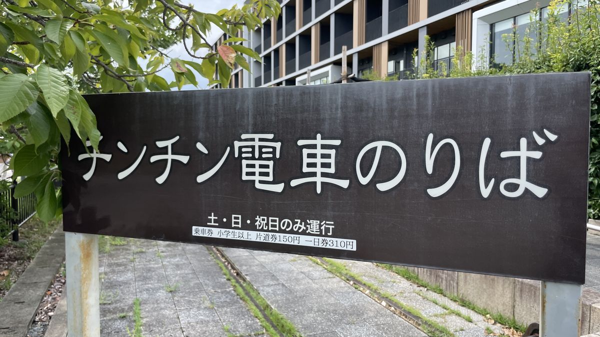 梅小路公園の「チンチン電車のりば」の看板。土・日・祝日のみ運行、片道券150円・一日券310円と書かれている